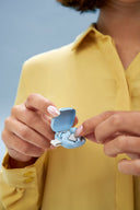 frau haelt silence in ihrer aufbewahrungsbox in soft blue in ihrer hand