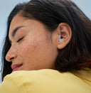 Eine Frau im Profil, die Alpine Silence Blue trägt.