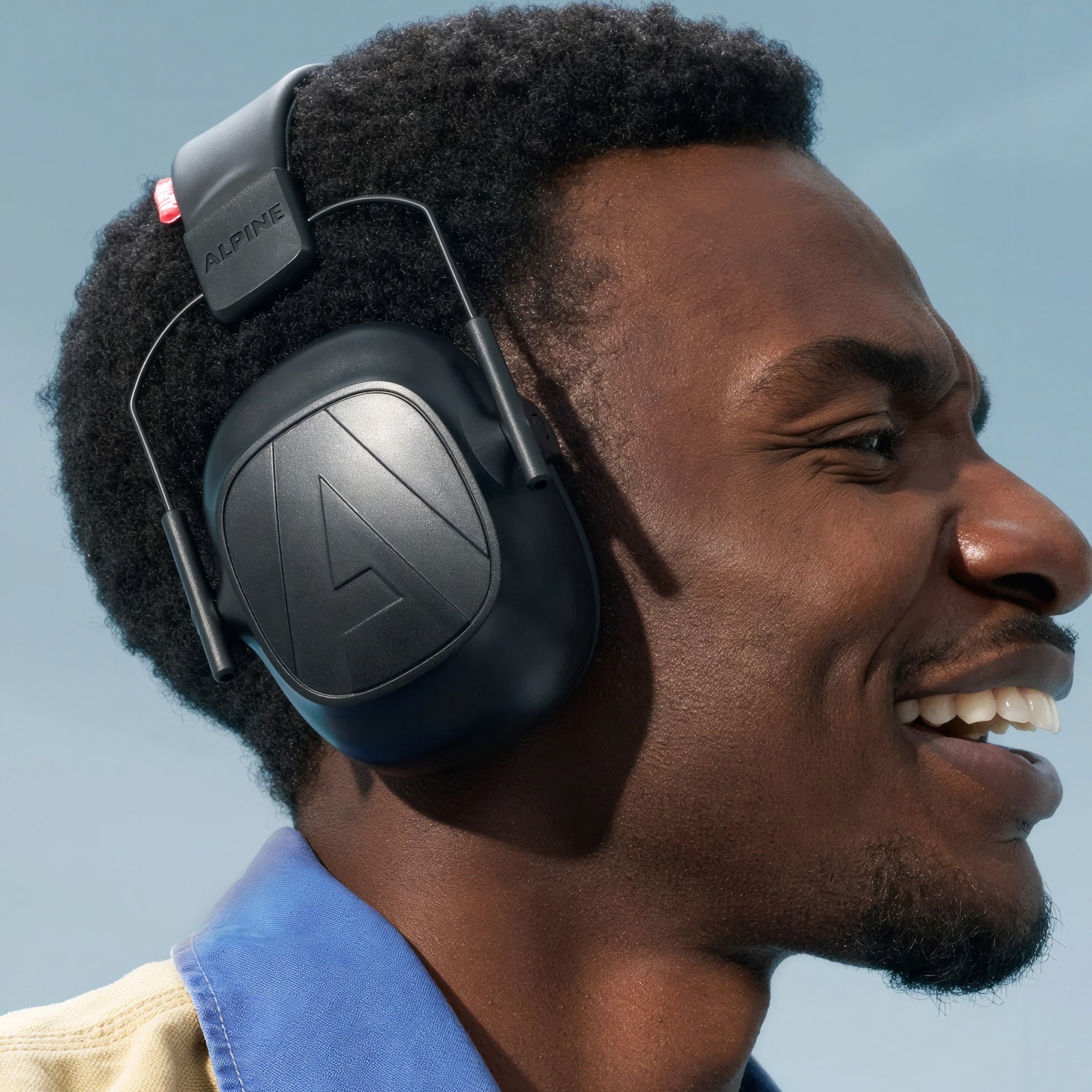 Smiling man wearing Alpine Defender earmuffs, side view