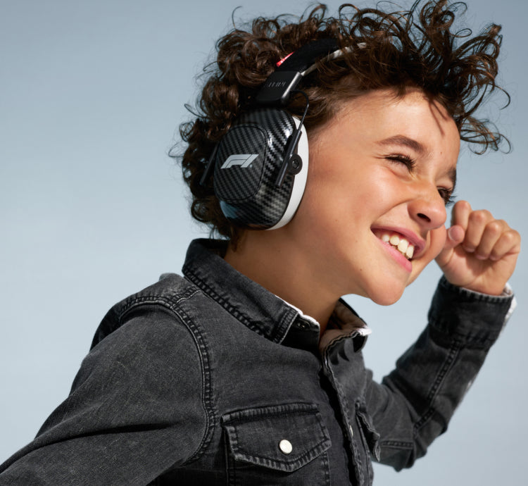 bild eines jungens der eine faust macht mit formel 1 ermuffs ueber ohr gehoerschutz