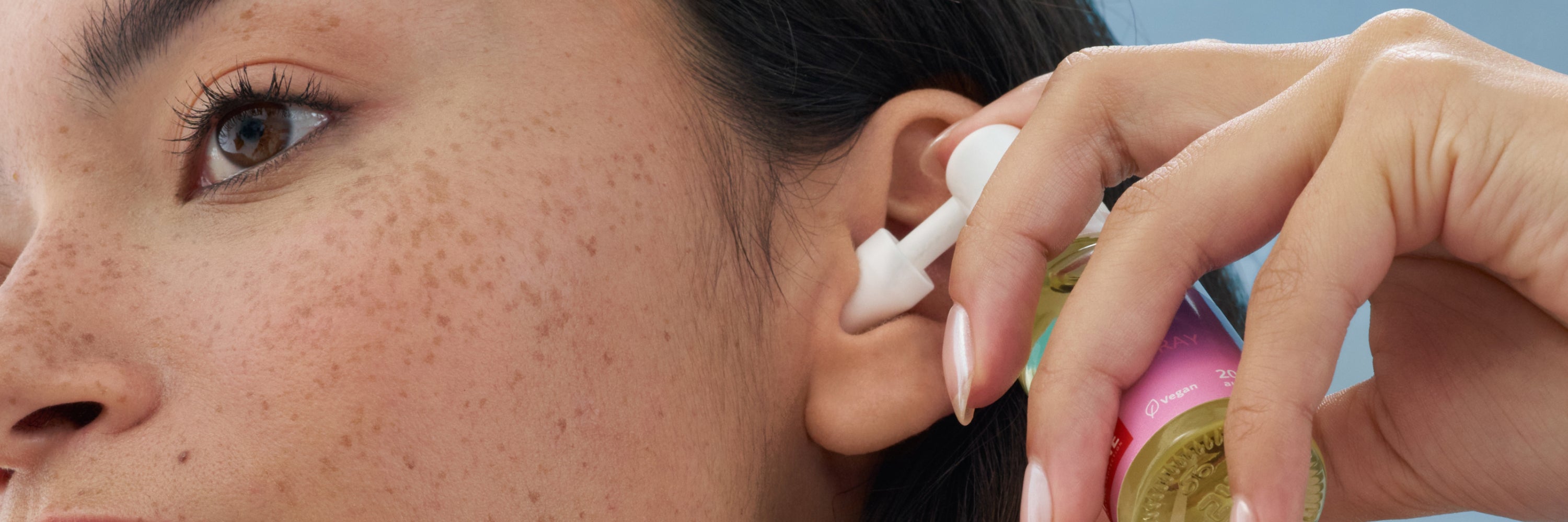 frau nutzt das alpine reinigungsspray um ihre ohren zu reinige