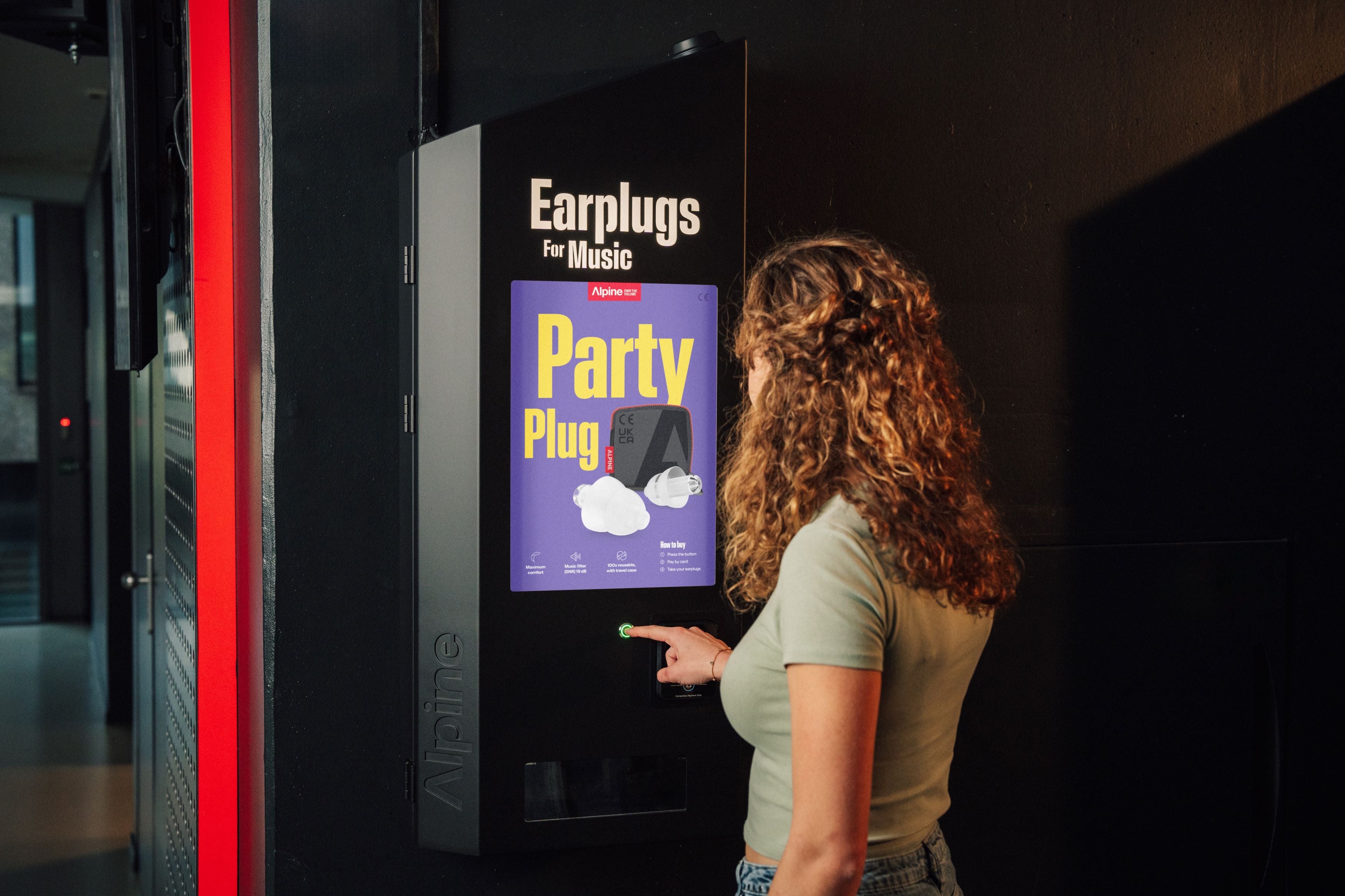 frau kauft ohrenschutz an alpine verkaufs automat