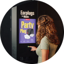 Frau nutzt alpine automaten um partyplugs zu kaufen