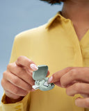 silence ohrschutz in der hand einer frau in gruen