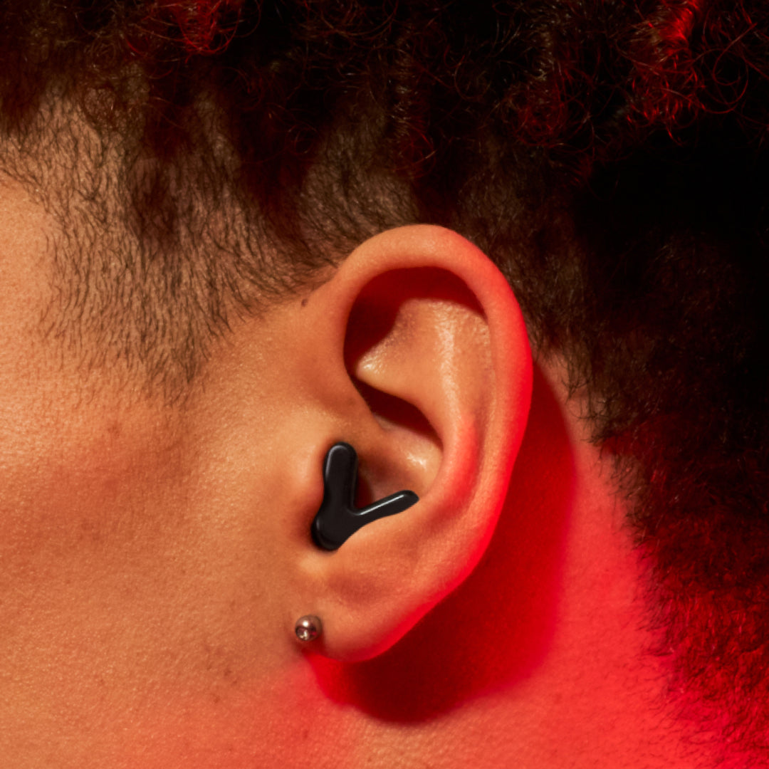 Detailed image of an ear with an Alpine Tune earplug in black showing the snug fit in ear 